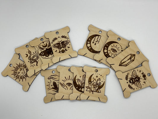 Set of wooden bobbins with engraved designs on a white background