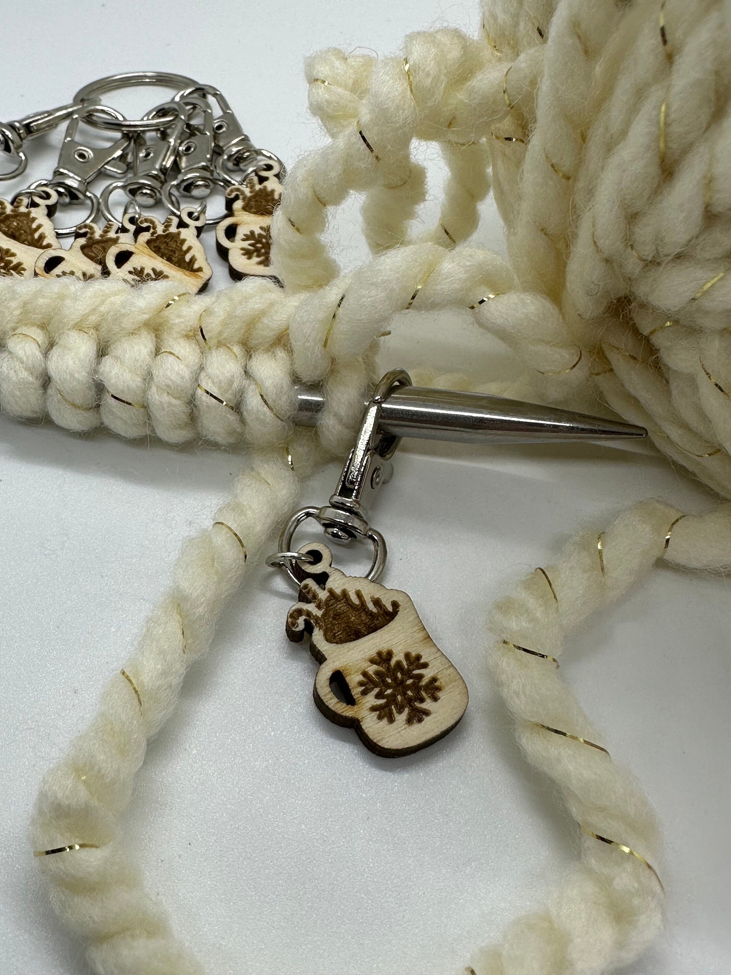 Close-up of a white braided yarn with a silver clasp and mug-shaped wooden charm on a white background.