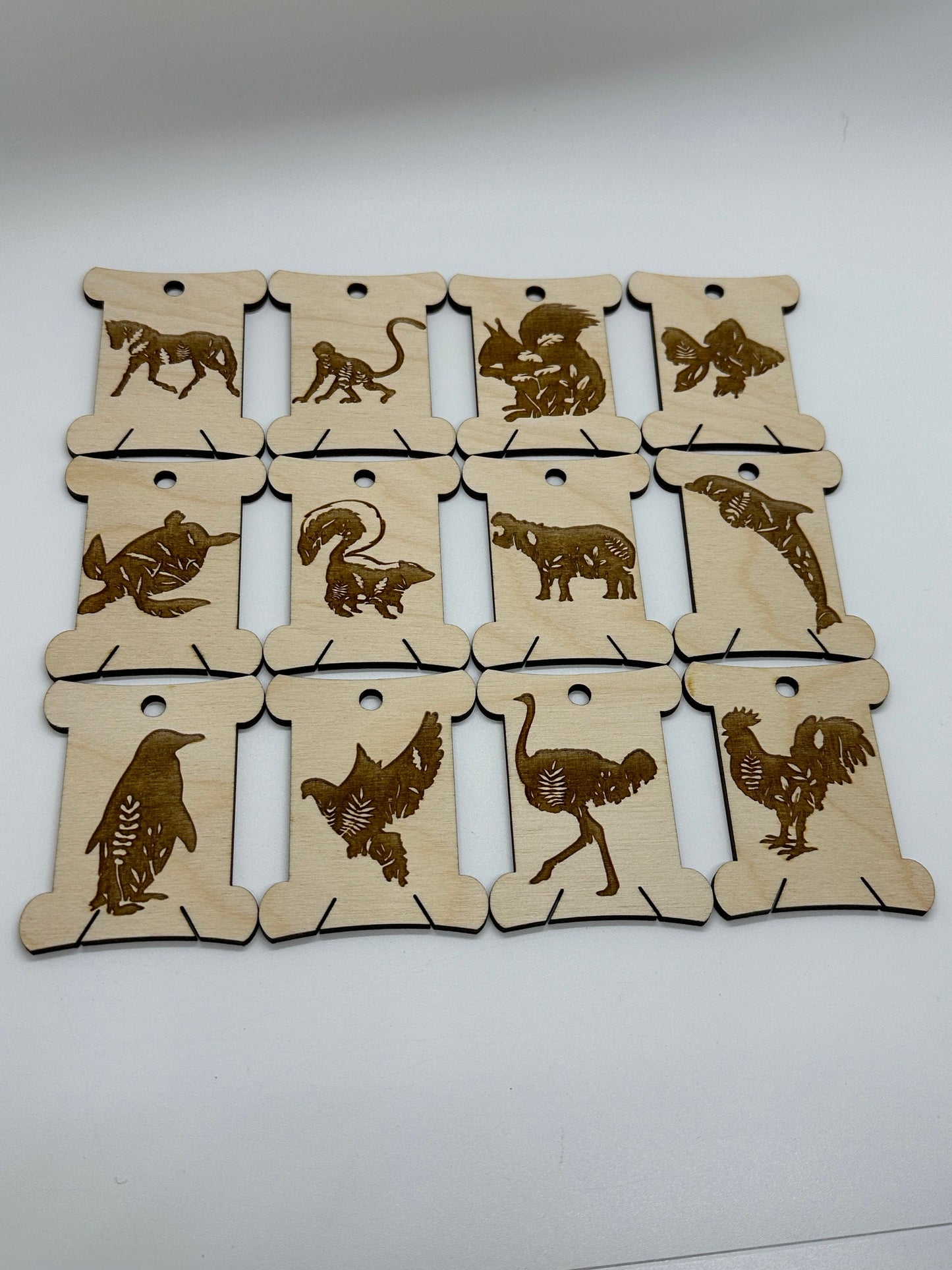 Set of wooden bobbins with animal illustrations on a white background