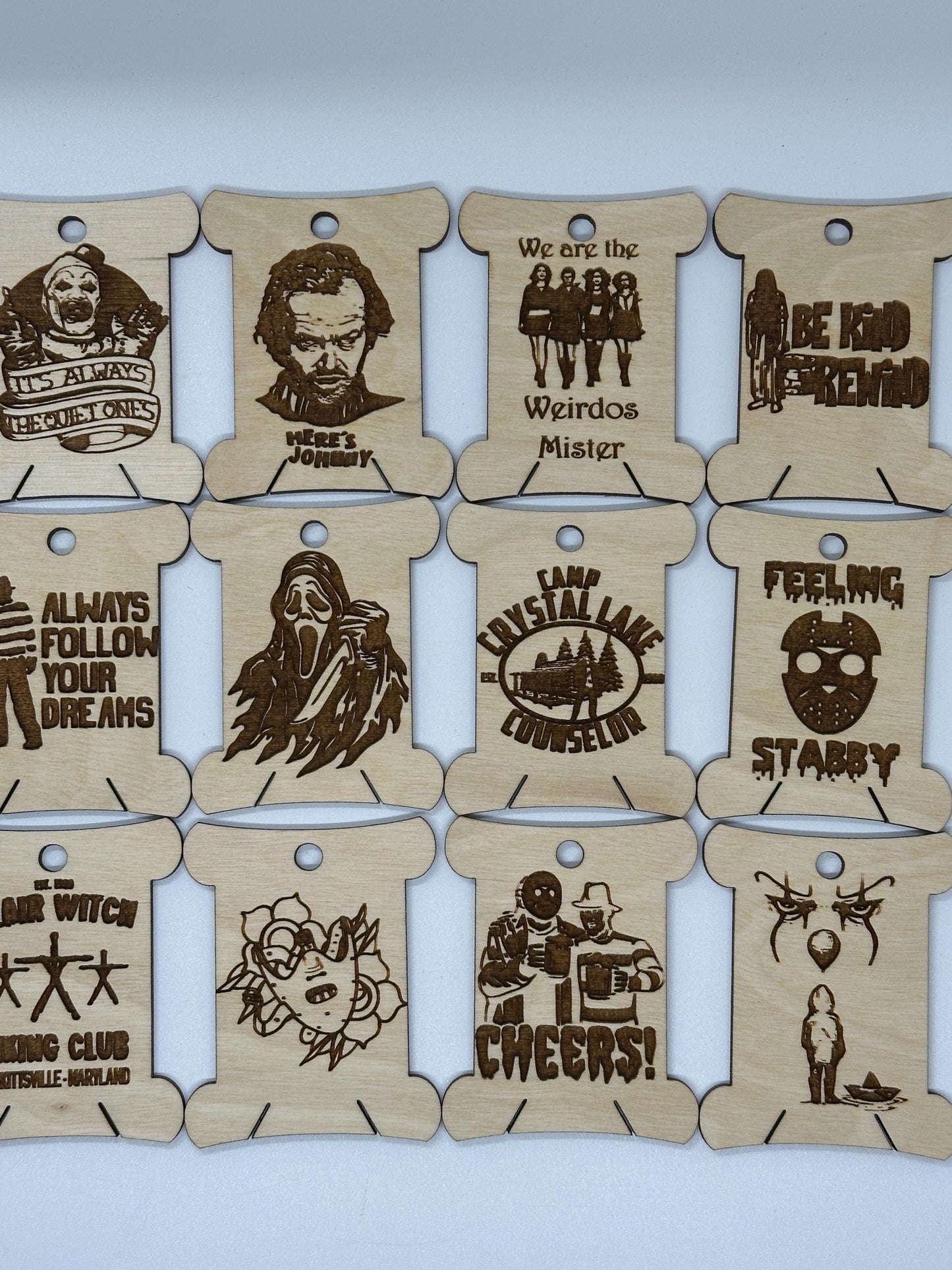 Set of wooden tags with laser-cut designs and text on a light blue background