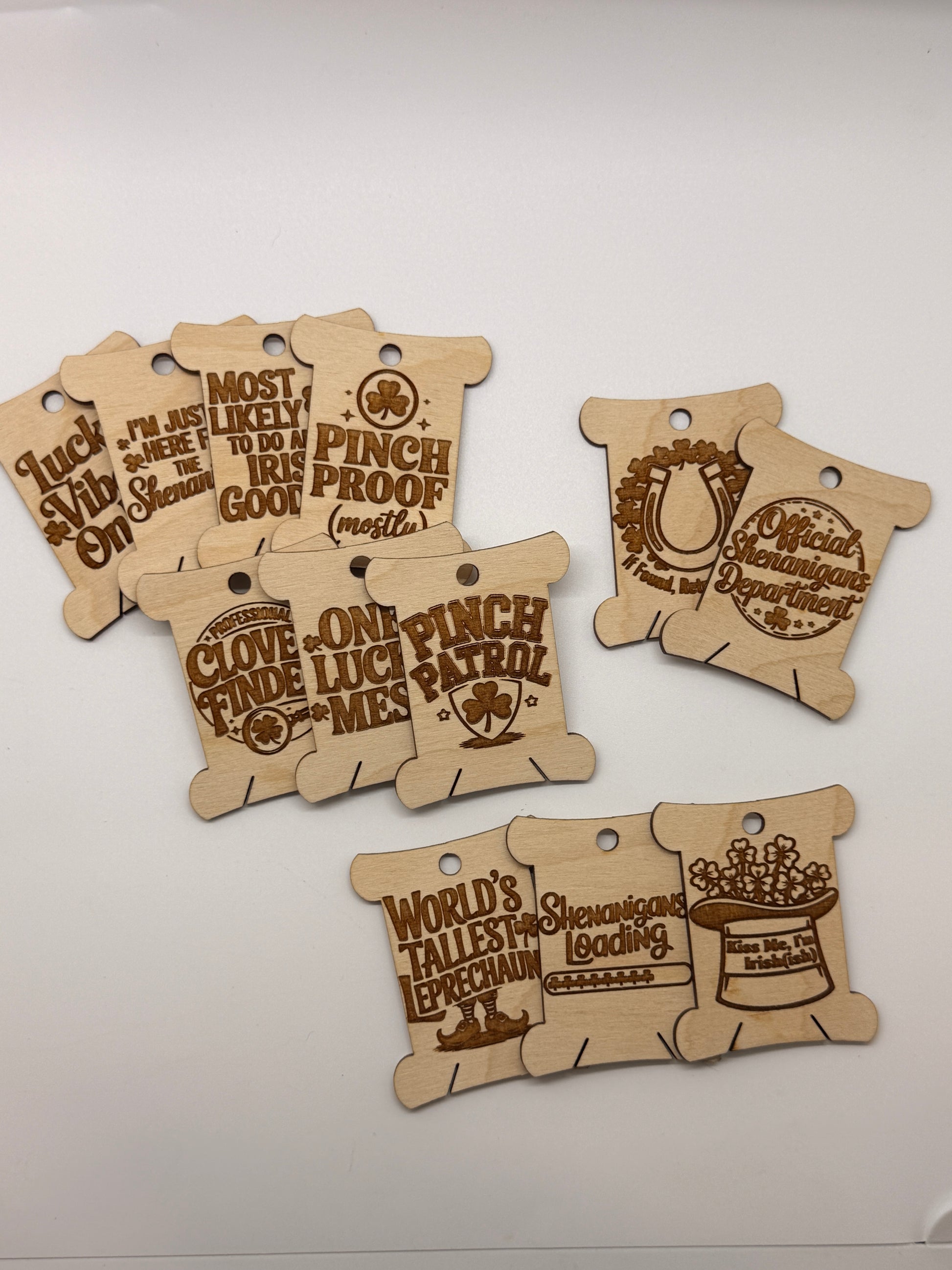 Four wooden bobbins with engraved text on a white surface