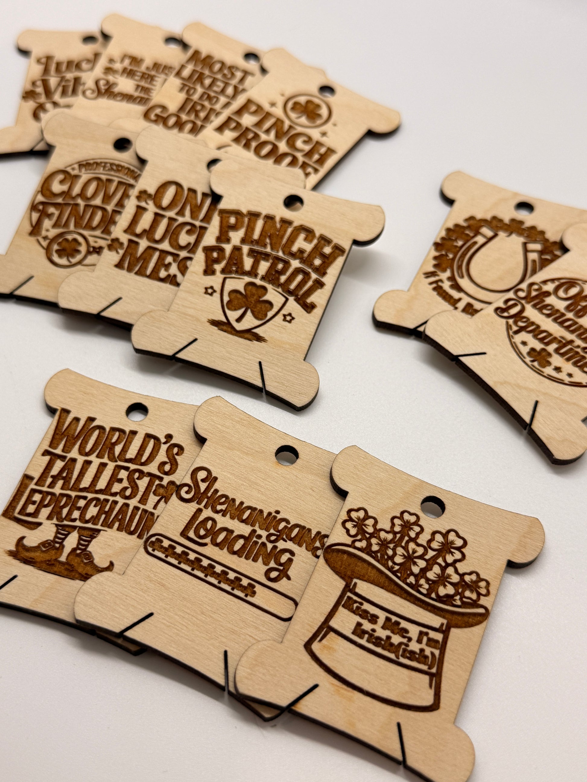 Wooden cutouts with engraved text and graphics on a white background