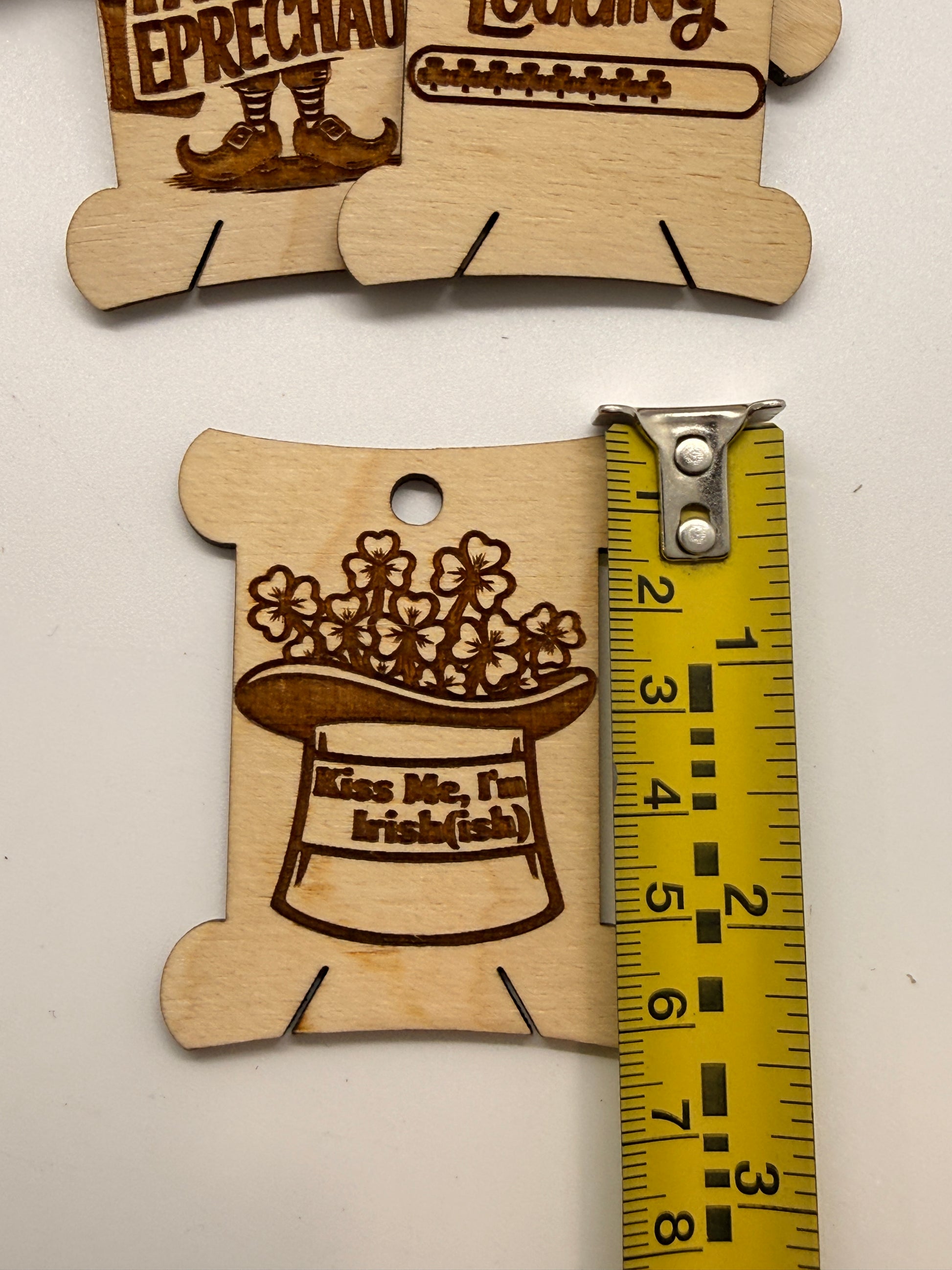 Wooden cutout with text and a ruler measurement on a white background