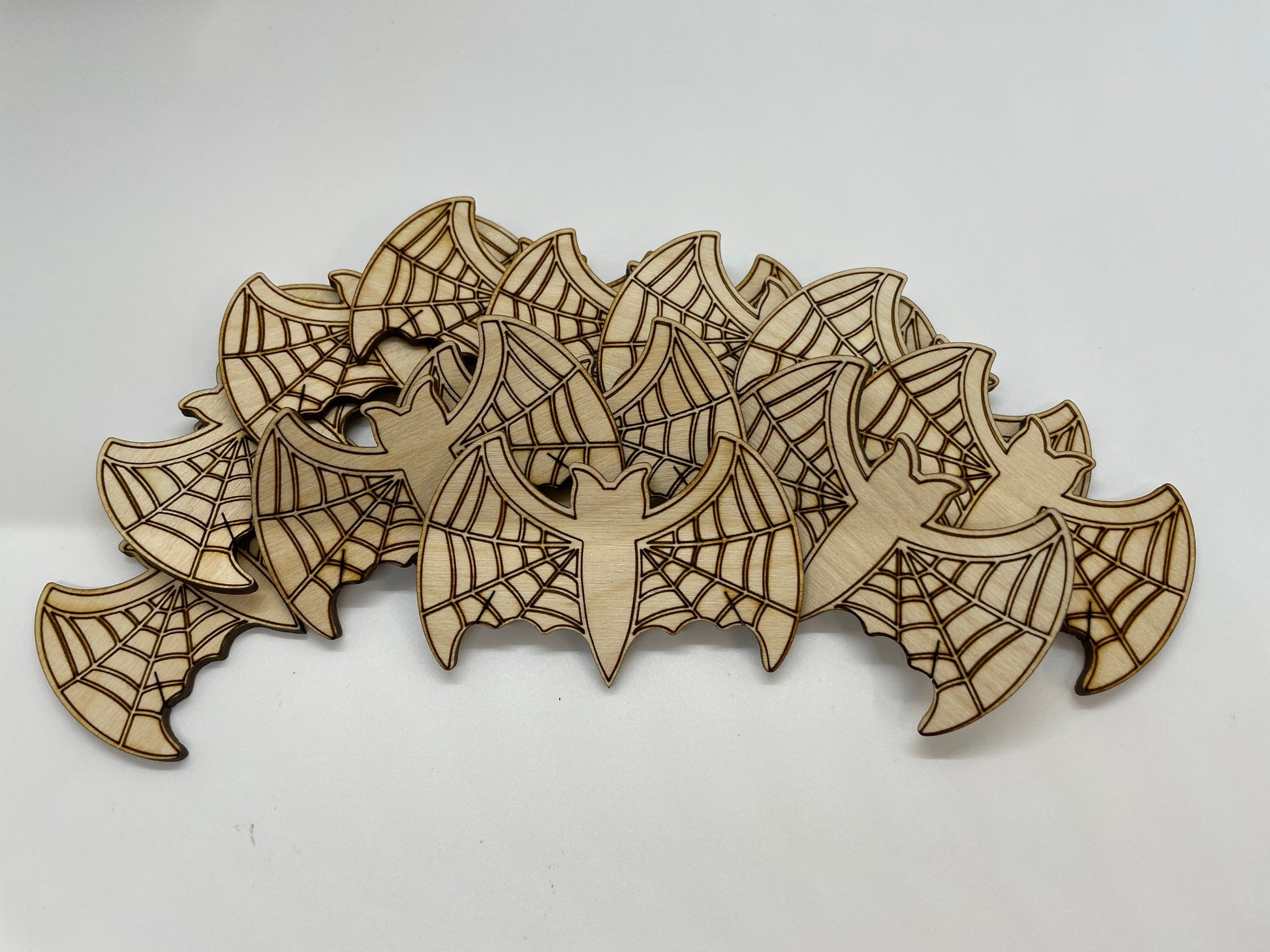Wooden cutout shapes of bats and webs on a white background