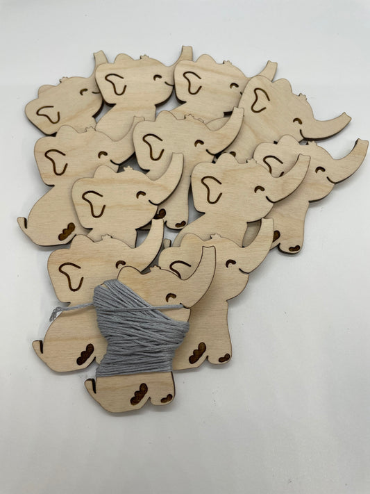 Wooden elephant cutouts with a ball of yarn on a white background