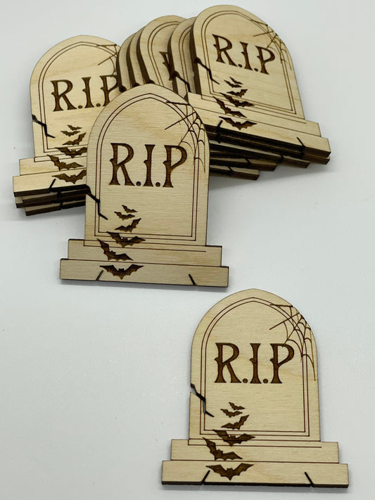 Wooden tombstone decorations with 'R.I.P.' text on a white background