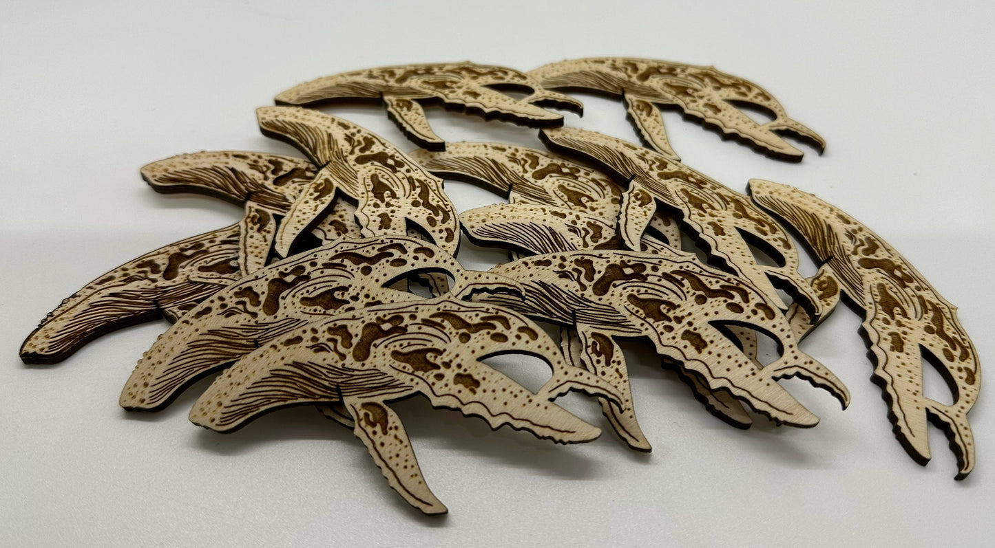 Wooden humpback whale cutouts on a white background