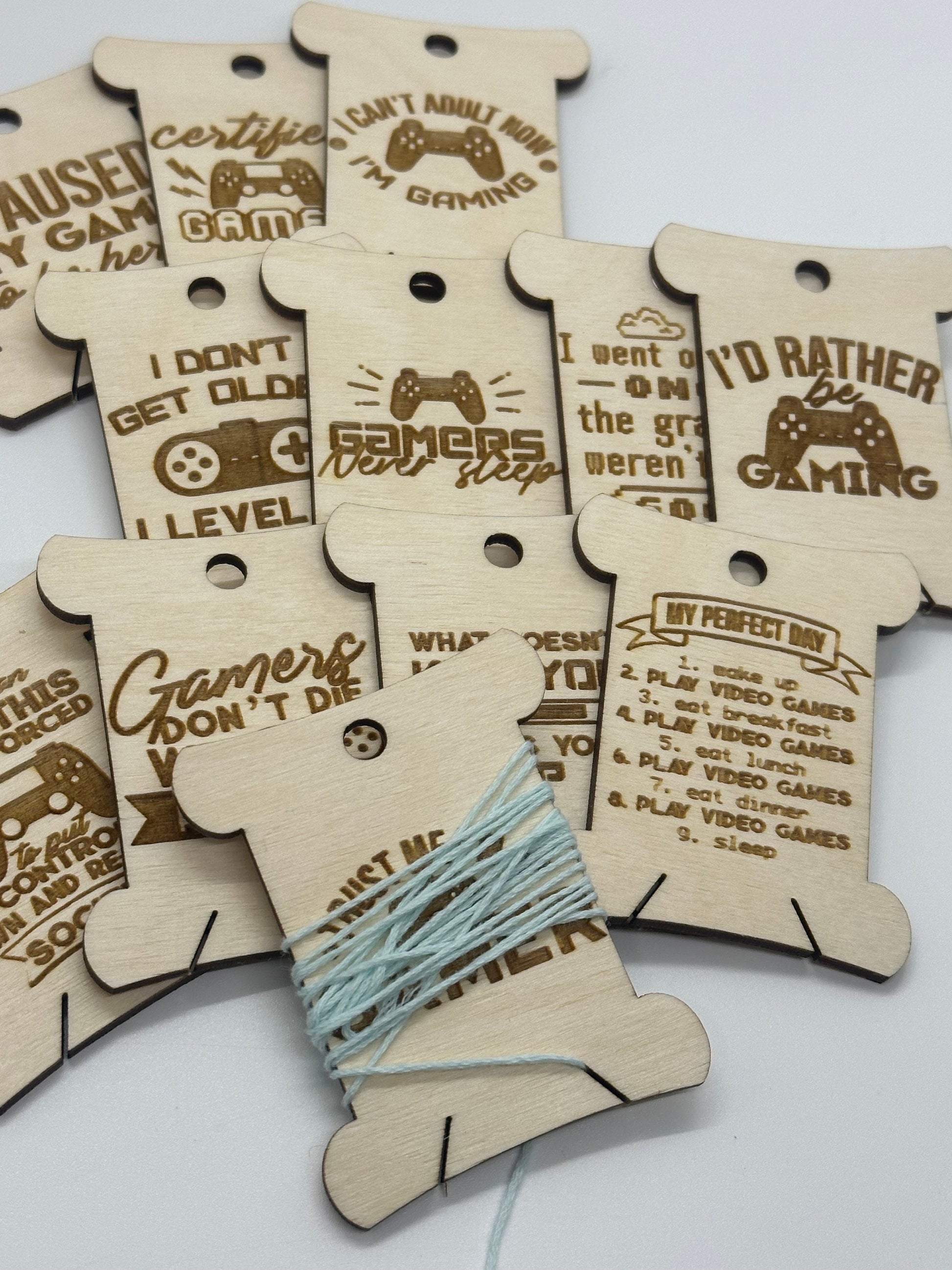 Wooden bobbins with gaming-themed sayings on a white background