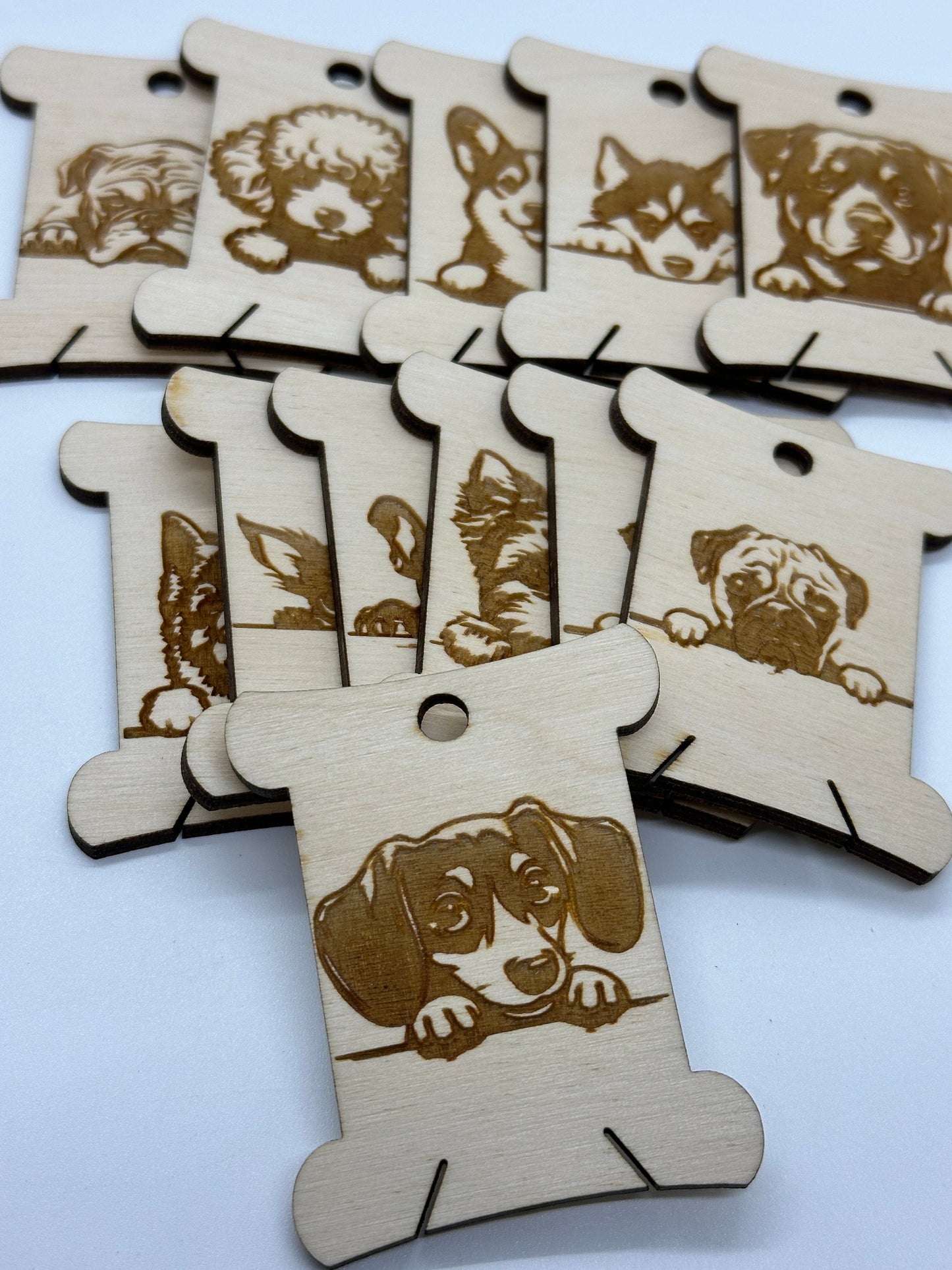 Wooden bobbins with dog illustrations on a white background