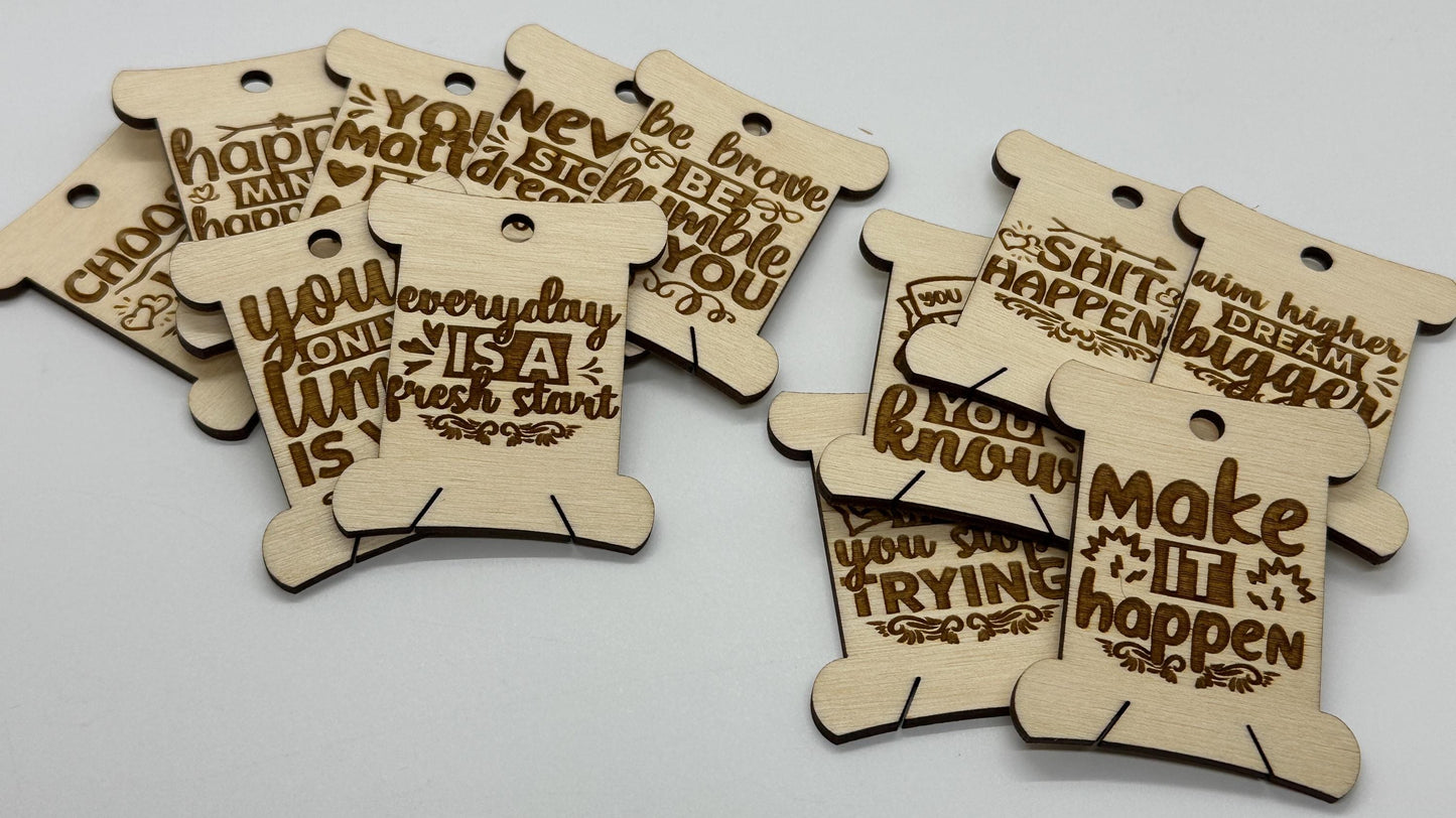 Wooden tags with motivational phrases on a light gray background