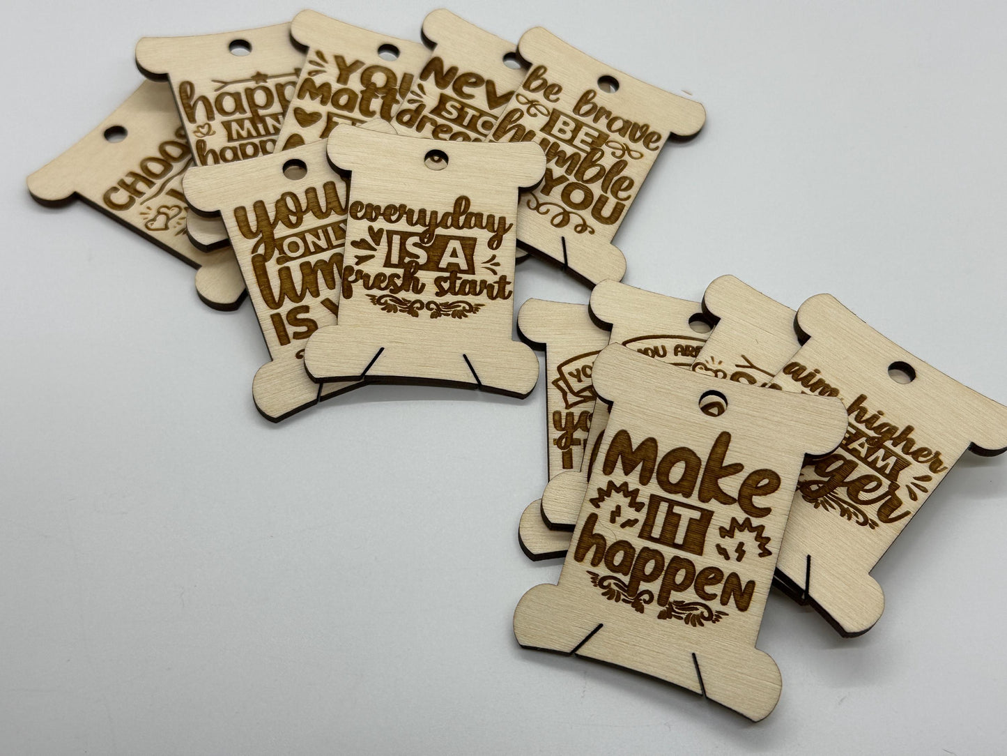 Wooden tags with motivational phrases on a light gray background