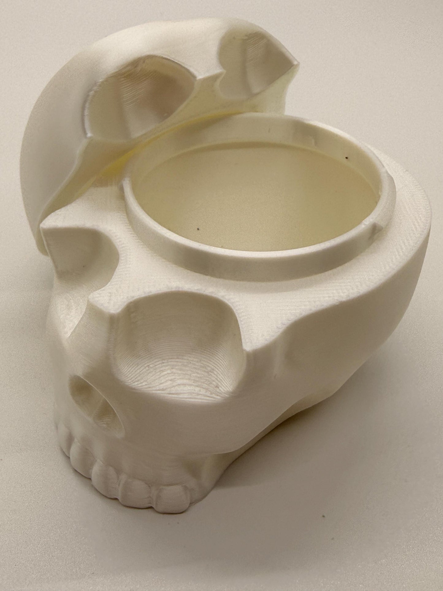 White skull-shaped container on a light gray background