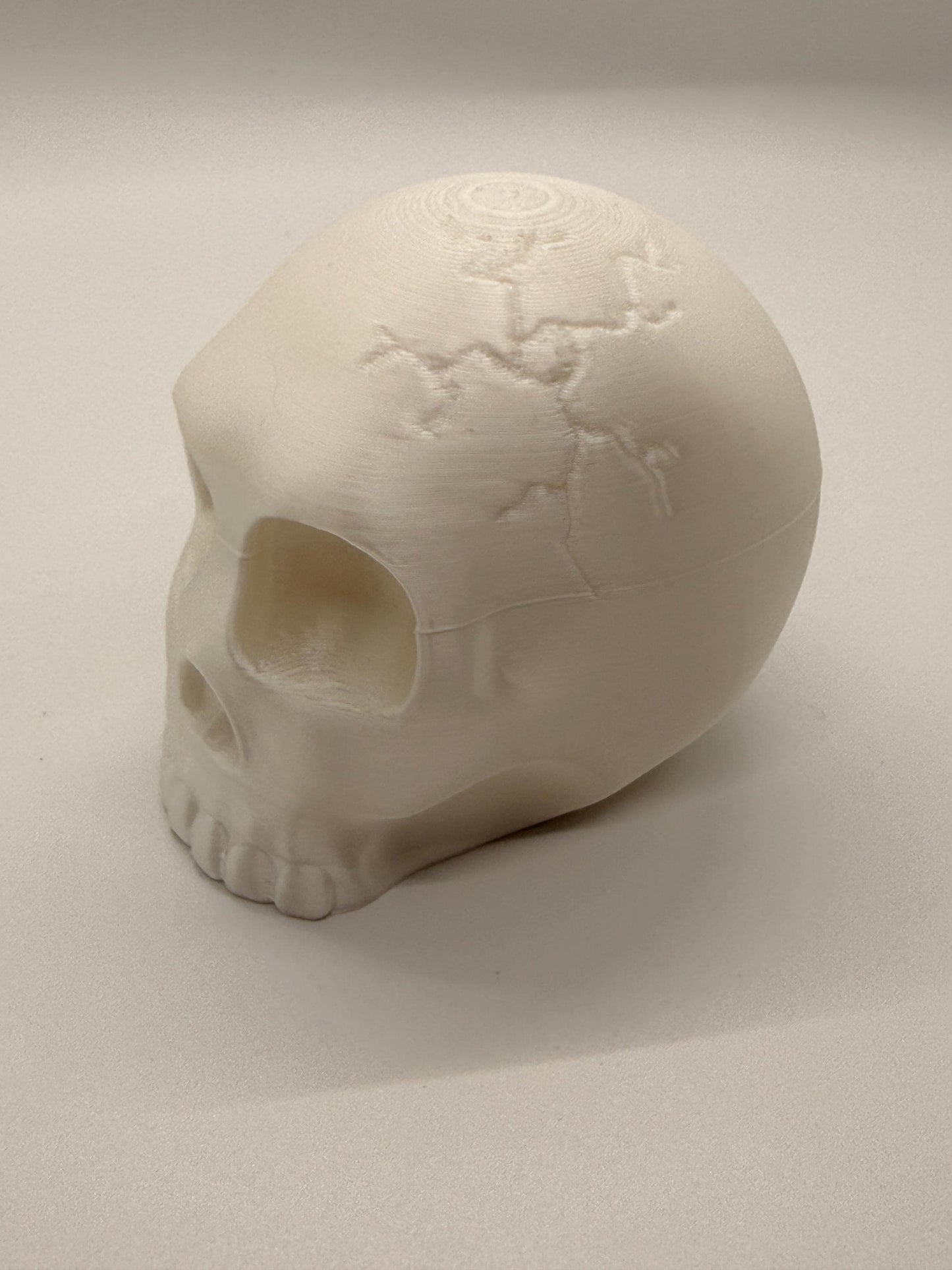 White skull-shaped object on a light gray background